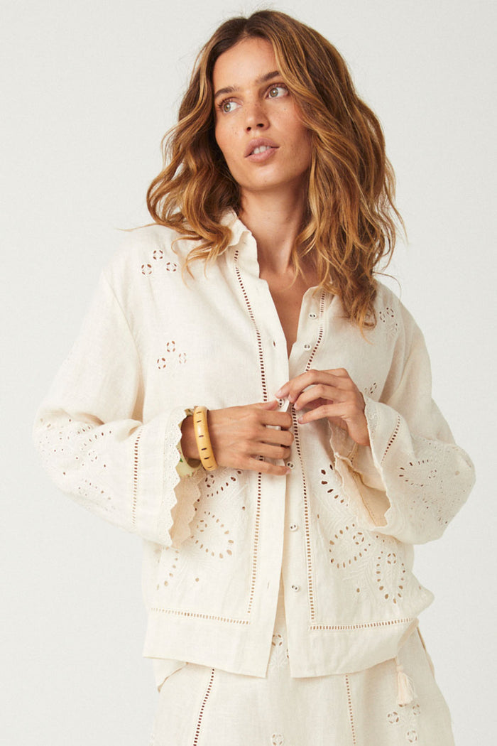 Front view of eyelet embroidery shirt in antique creme with scallop lace cuffs and button placket