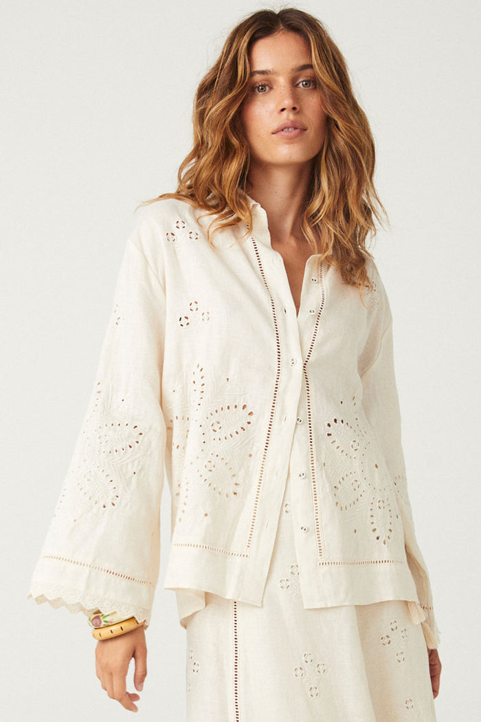 Front-facing close-up of eyelet embroidery, scallop lace hem, and ladder lace placket on antique creme shirt