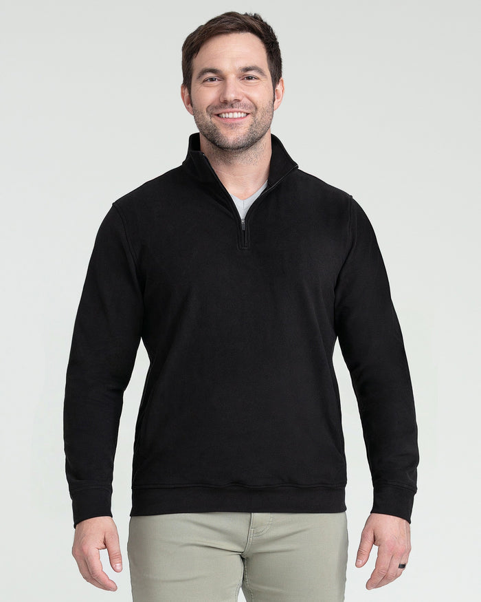 Black quarter zip pullover with long sleeves and ribbed cuffs, worn with khaki pants.