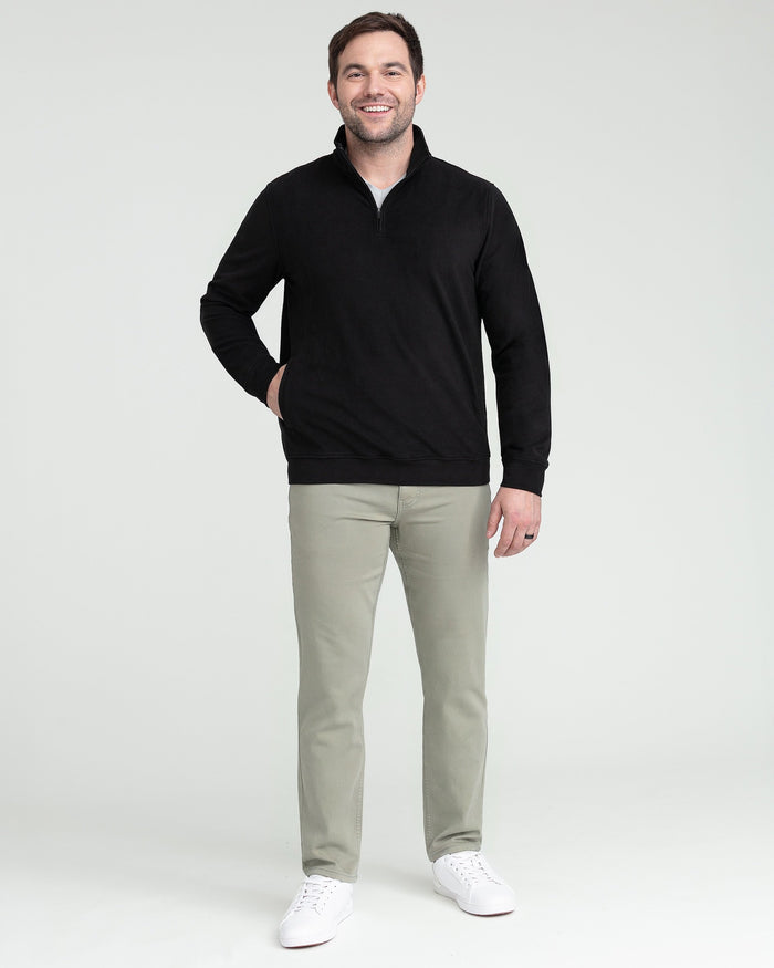 Black quarter zip pullover with ribbed collar and cuffs, styled with khaki pants.
