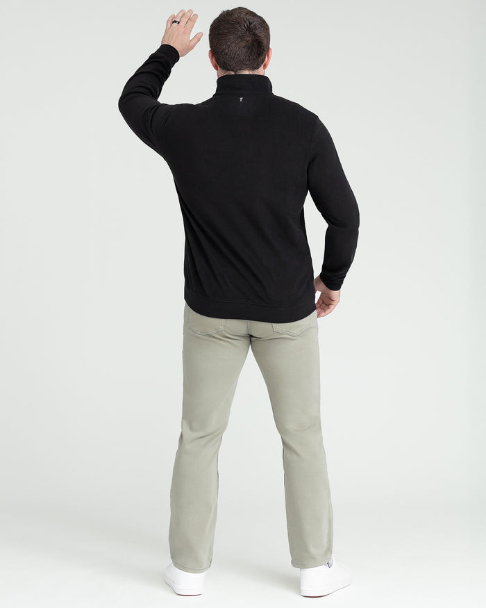 Black quarter zip pullover with stand collar, shown from back on model wearing tan pants.