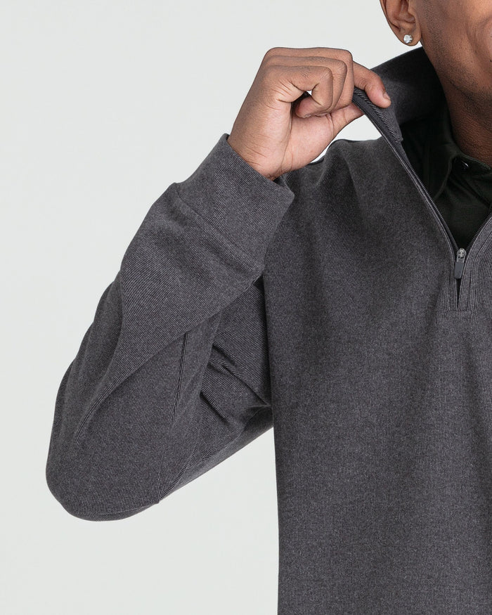 Charcoal heather quarter zip pullover with ribbed texture, shown on model pulling up the zipper.