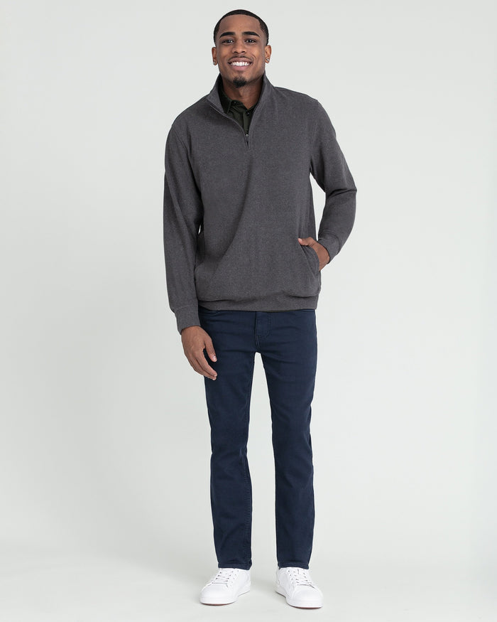 Charcoal heather quarter zip pullover with ribbed collar worn with dark jeans and white sneakers.