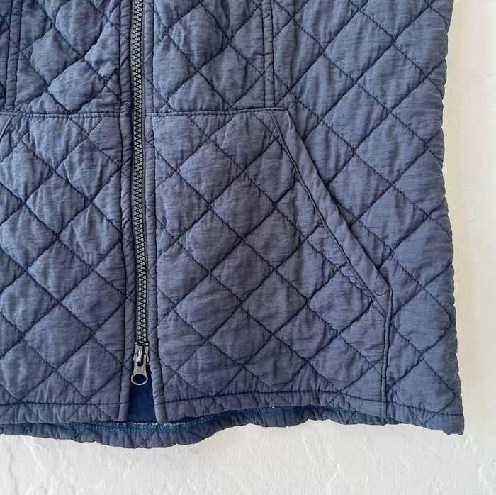 Close-up of quilted blue jacket on a white background