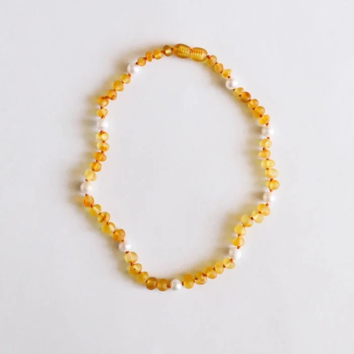 CanyonLeaf Amber + Pearl Gemstone Necklace — a hand-knotted beaded necklace alternating  honey amber beads in golden yellow with pearl beads, with a screw clasp, laid flat on a white background