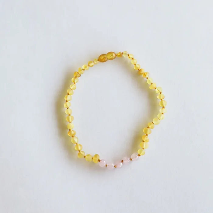 CanyonLeaf raw honey Baltic amber and rose quartz beaded necklace with hand-knotted cord and screw clasp, laid flat on a white background