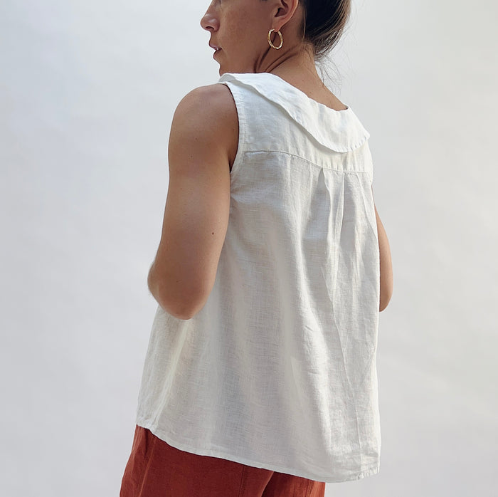 Back view of the Sailor Tank in White by Yuvita, showing the sailor collar, pleated back yoke, and relaxed linen drape in white, styled with terracotta linen wide-leg pants