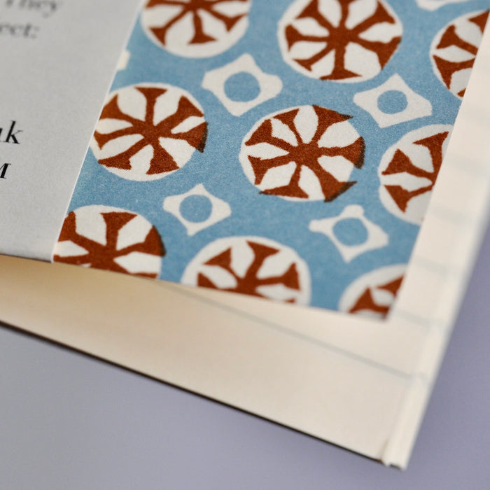 Patterned paper with brown and white circular design on a blue background