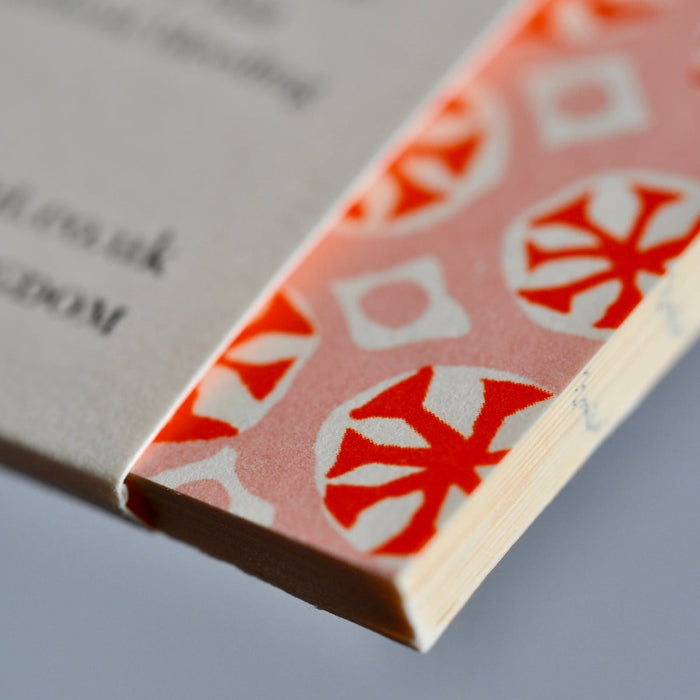 Close-up of a book with a red and white patterned cover