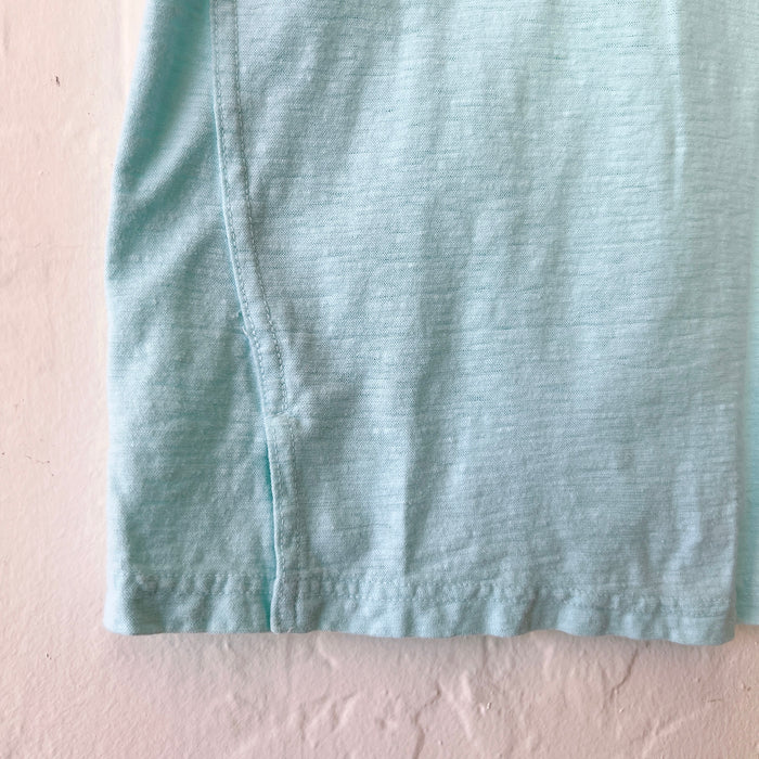 Close-up of light blue fabric on a textured beige surface