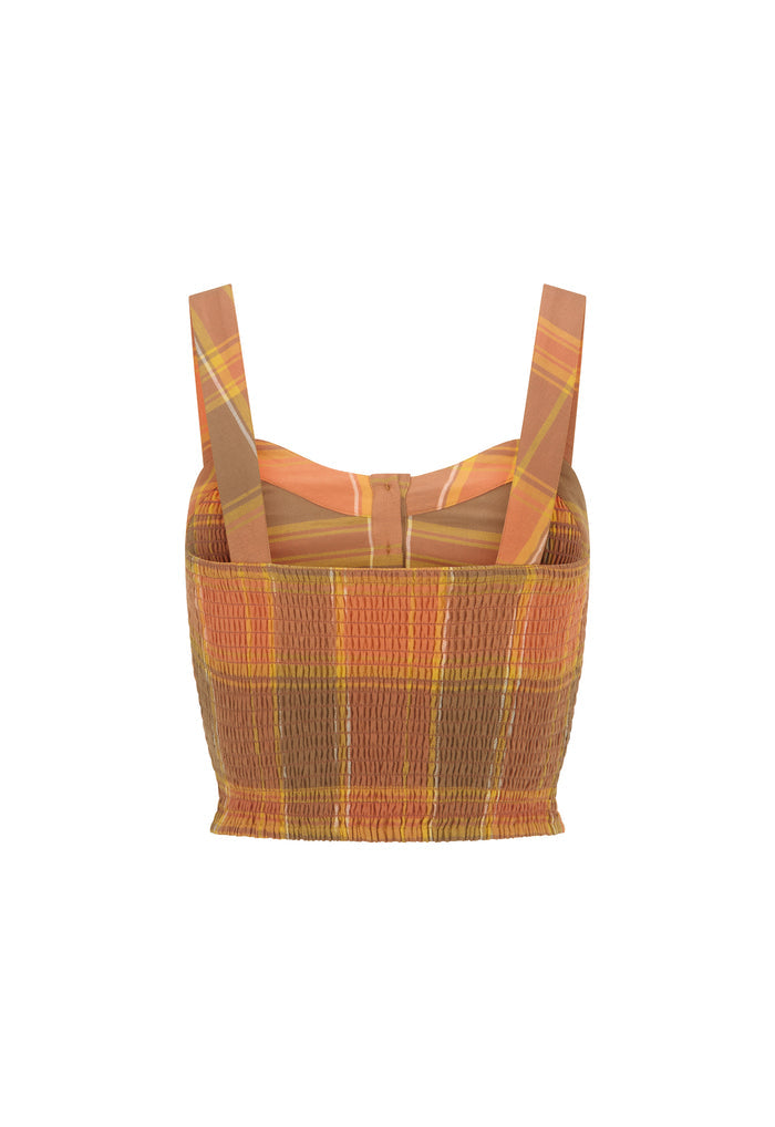 A cropped knit top with a textured smocked body and wide shoulder straps, featuring a warm plaid pattern in orange, brown, and yellow, shown against a plain white background.