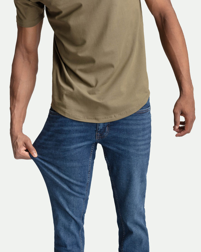 Man wearing tan short-sleeve t-shirt and medium blue skinny fit jeans.