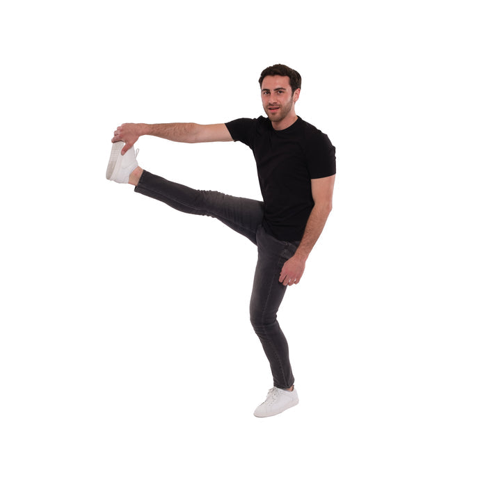 Man wearing black short-sleeve shirt and grey skinny fit jeans in a stretched pose.