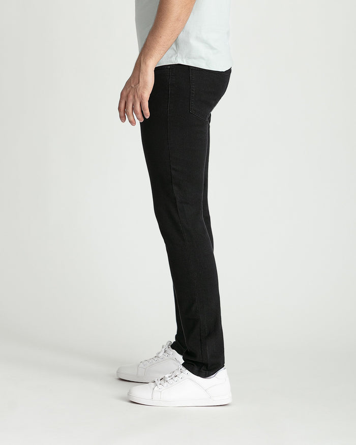 Man wearing black skinny fit jeans with white sneakers and light gray t-shirt.