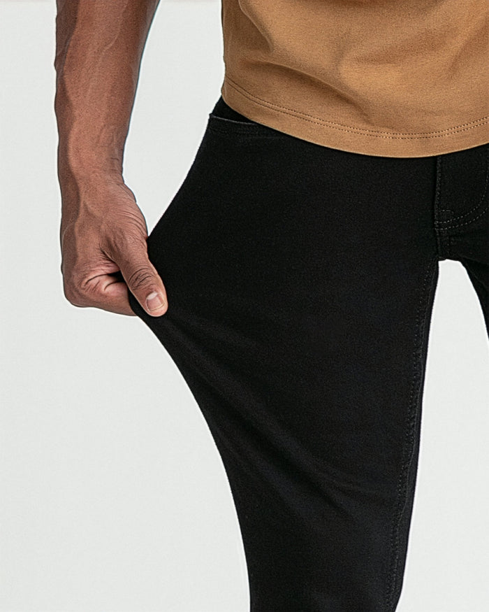 Black skinny fit jeans with visible stitching detail, shown on model wearing tan top.