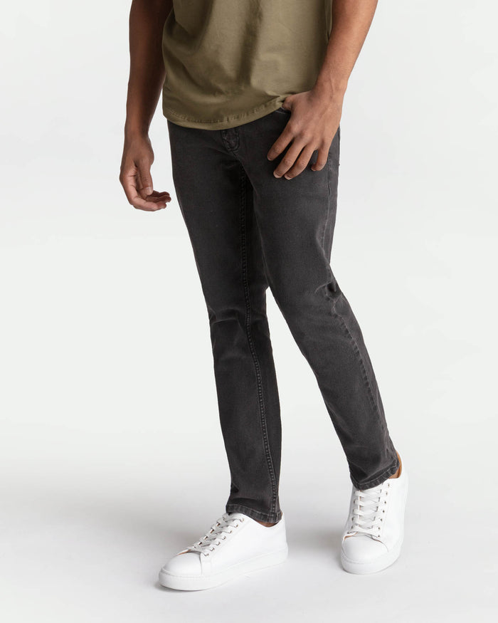 Faded black skinny fit jeans with a tapered leg and five-pocket construction.