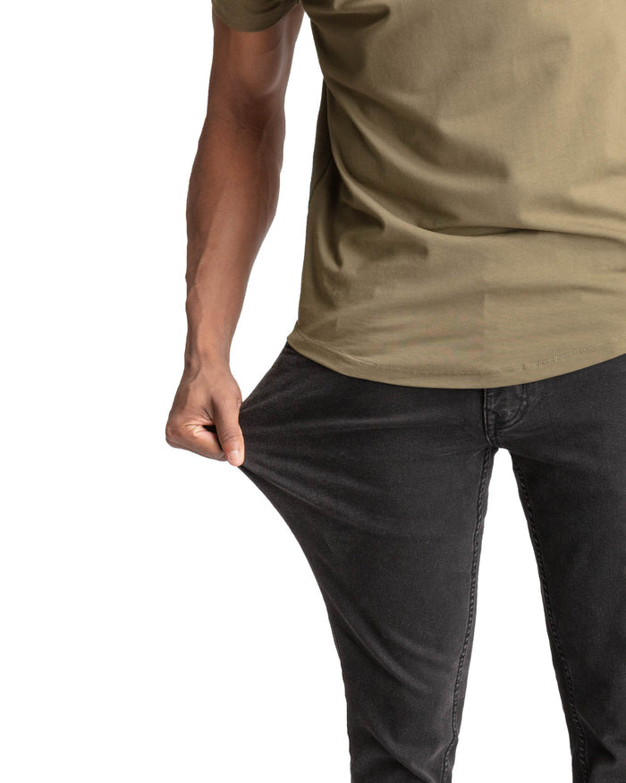 Faded black skinny fit jeans worn with a tan t-shirt, shown on model from waist down.
