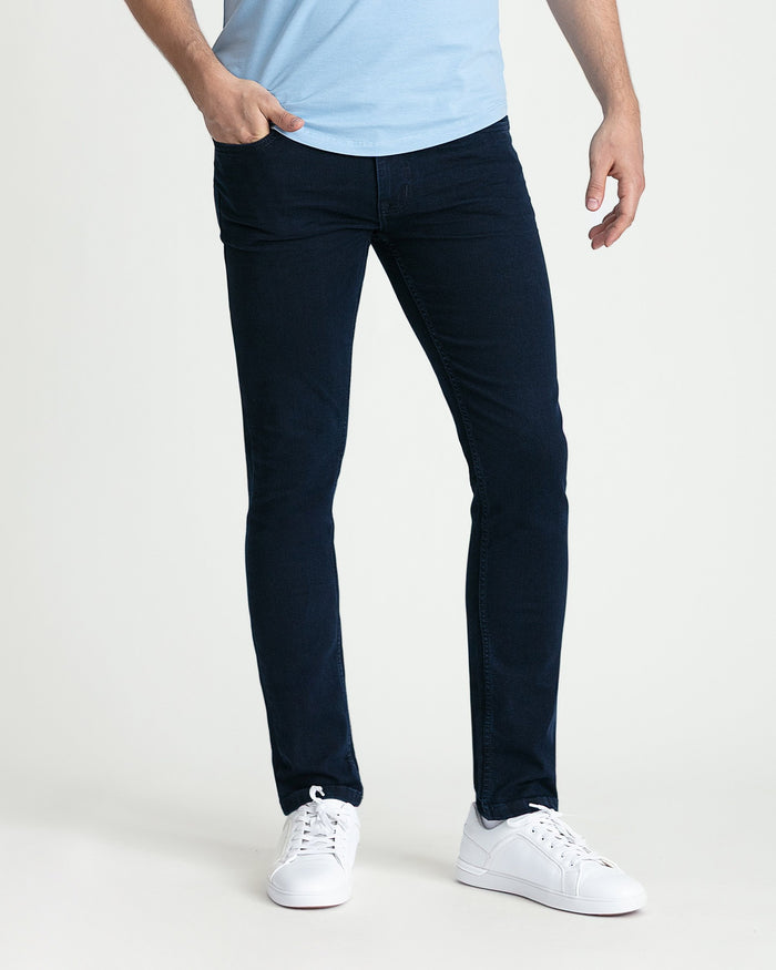 Man wearing light blue t-shirt and dark blue skinny fit jeans with white sneakers.
