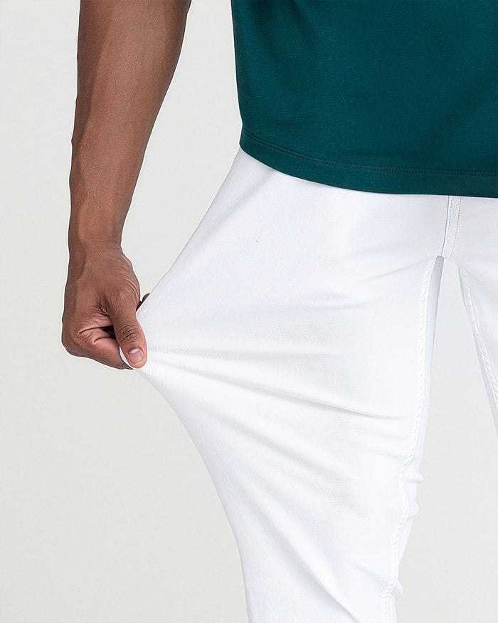 White slim fit pants with waistband detail, shown on model wearing teal shirt.