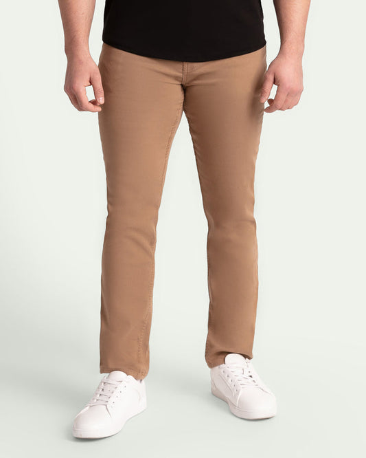 Man wearing dark khaki slim fit pants with black shirt and white sneakers.