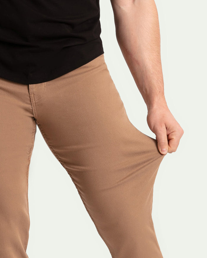 Dark khaki slim fit pants shown on model wearing black shirt.