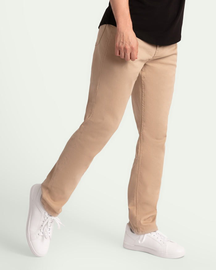 Light khaki slim fit pants worn with black shirt and white sneakers.