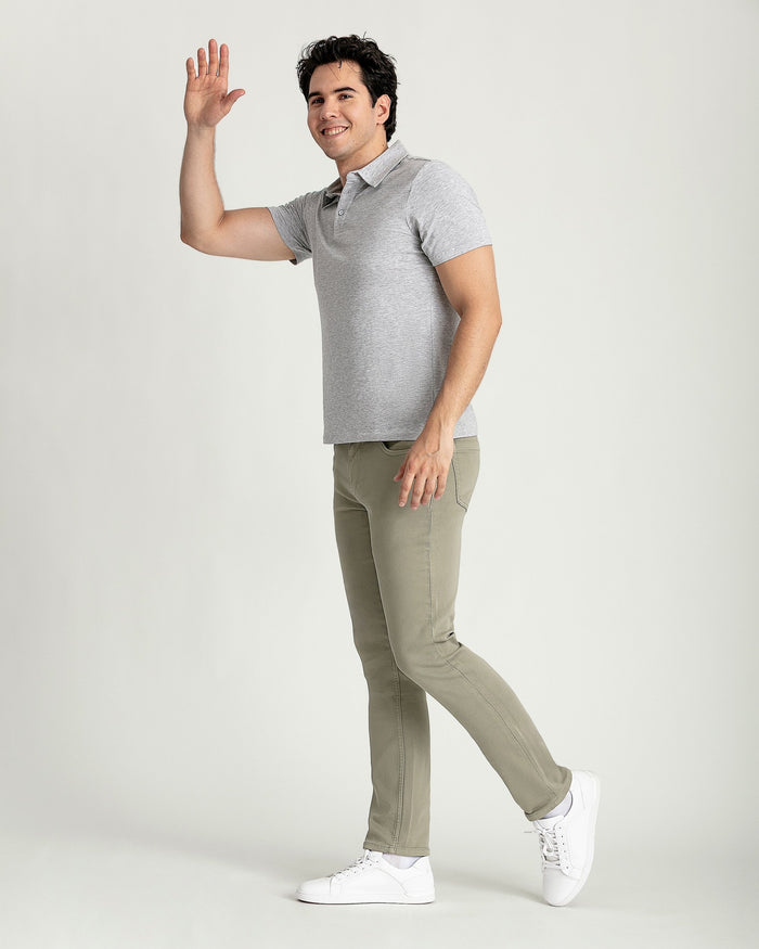 Man wearing light gray polo shirt and sage green slim fit pants with white sneakers.