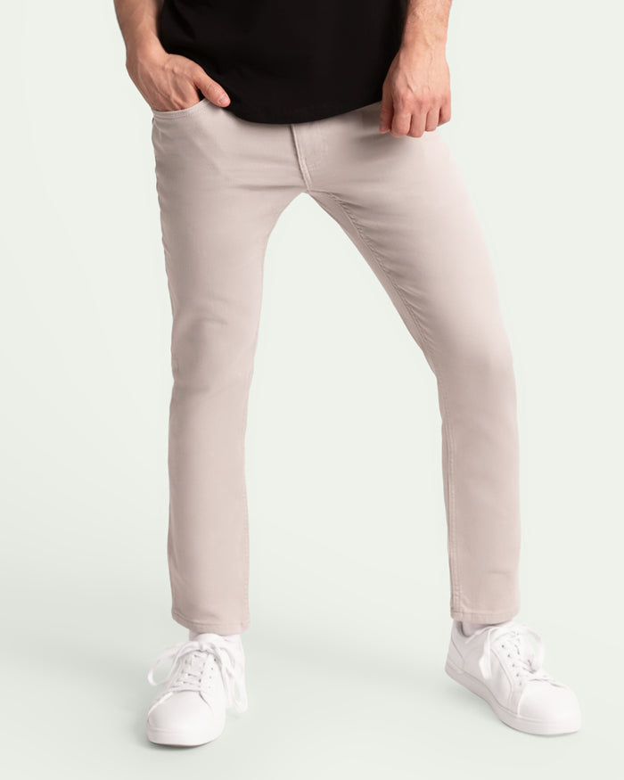 Light grey slim fit pants on a man wearing a black shirt and white sneakers.