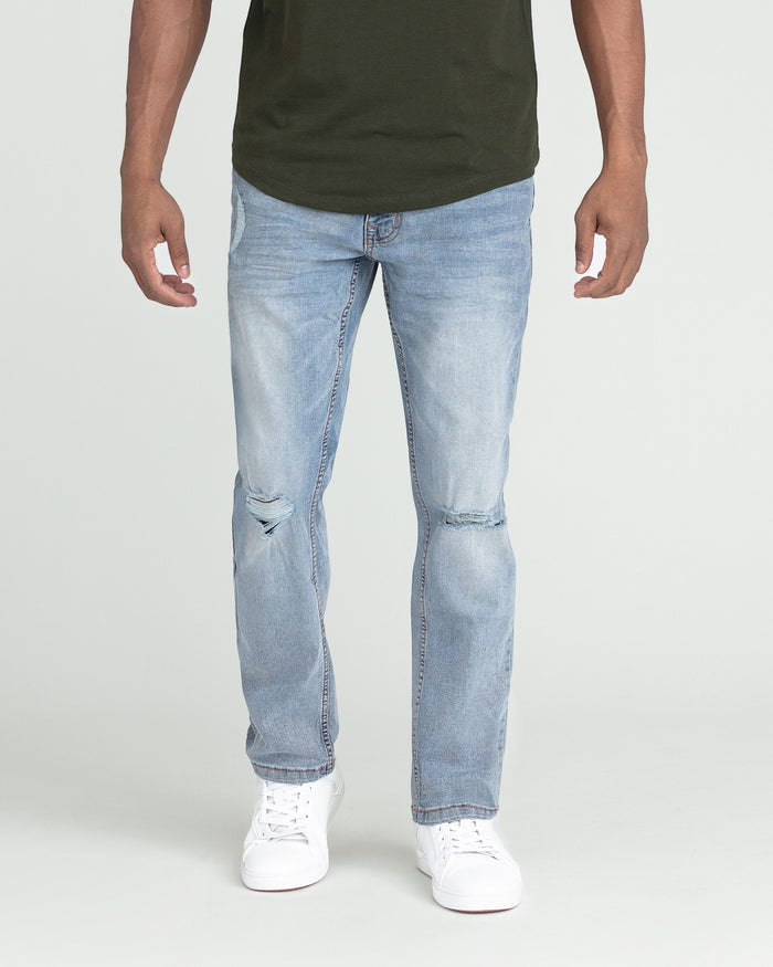 Light blue slim fit jeans with ripped knees, worn with olive green t-shirt and white sneakers.