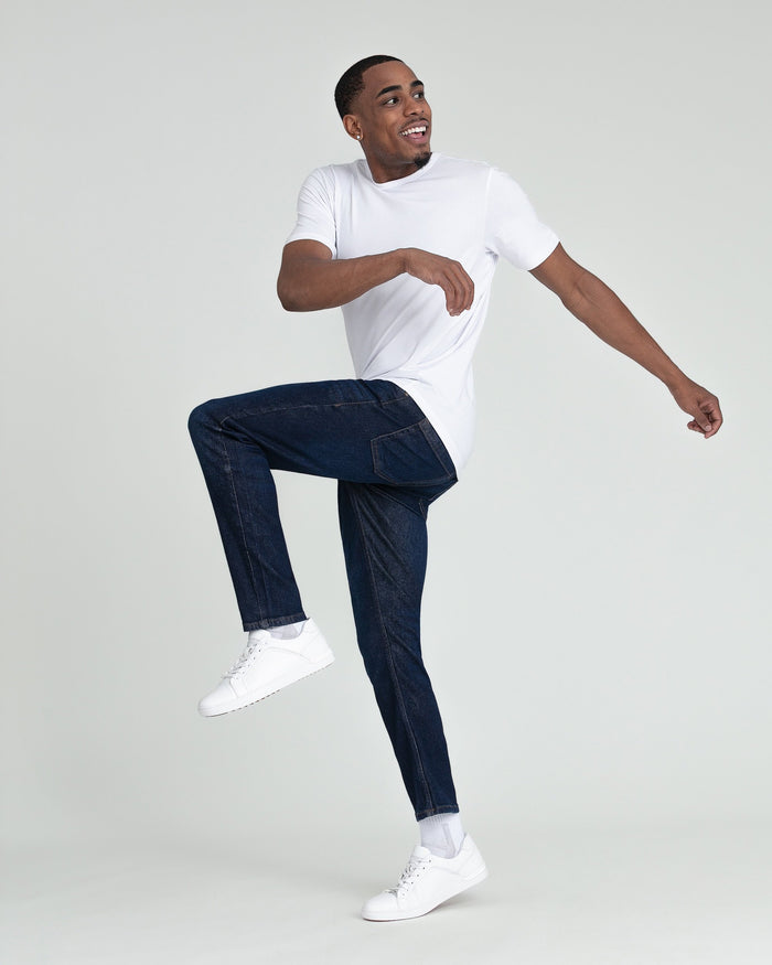 Man wearing white t-shirt and dark blue slim fit jeans with white sneakers.