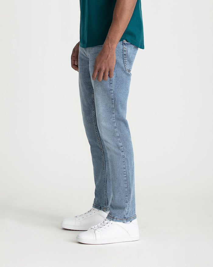 Light blue slim fit jeans worn with a teal shirt and white sneakers.