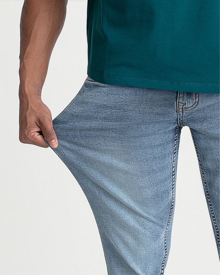 Man wearing dark teal short-sleeve shirt and light blue slim-fit jeans.
