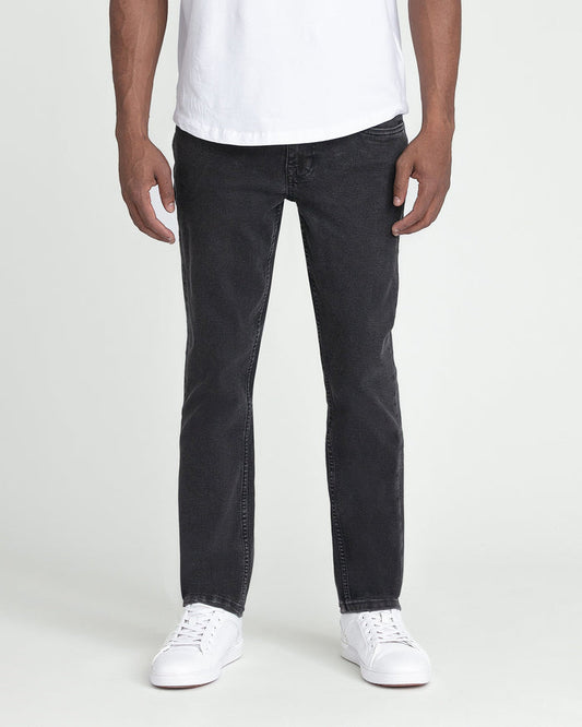 Man wearing white t-shirt and faded black slim fit jeans with white sneakers.
