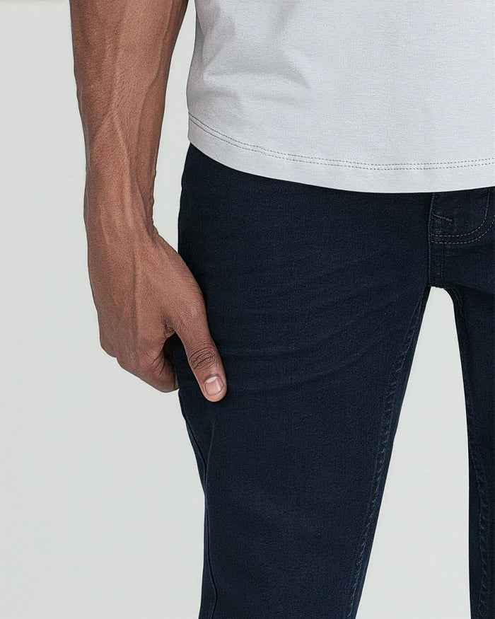 Man wearing light gray t-shirt and deep blue slim fit jeans.