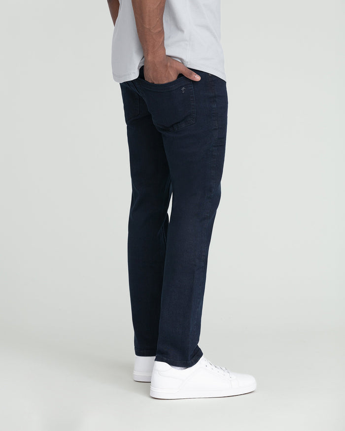Deep blue slim fit jeans with white sneakers and white shirt.
