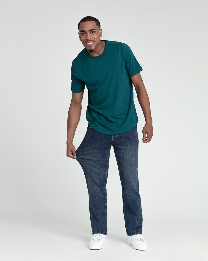 Man wearing teal short-sleeve t-shirt and dark blue jeans with white sneakers.