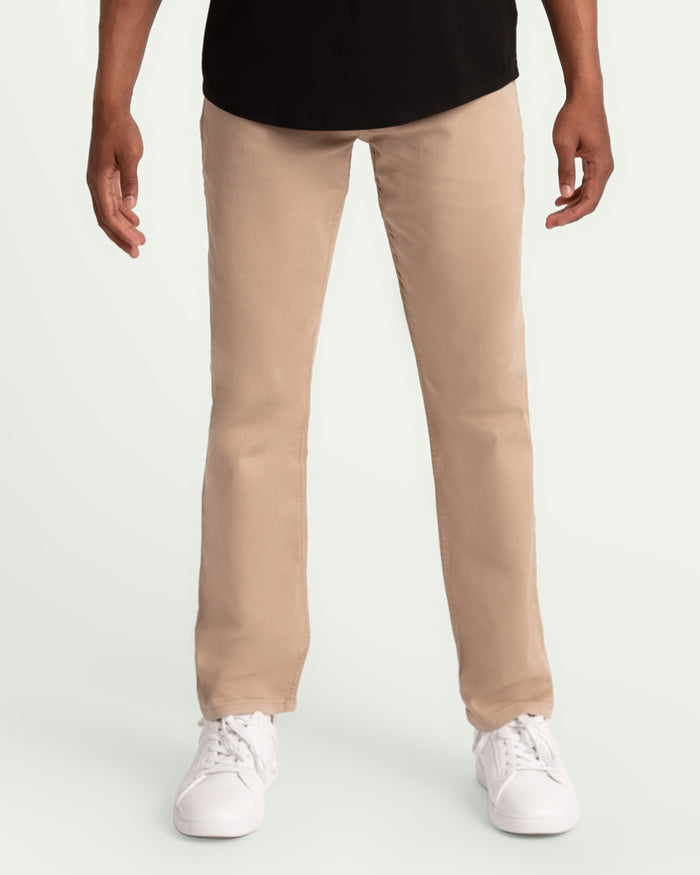 Light khaki slim fit pants on model wearing black shirt and white sneakers.