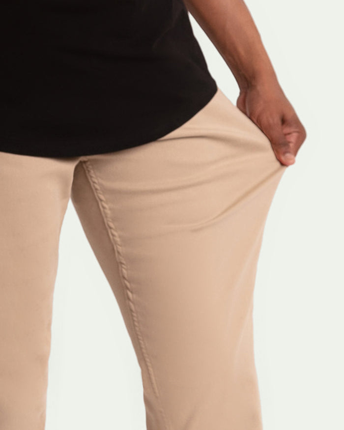 Light khaki slim fit pants with seamed leg detail, shown on model wearing black top.