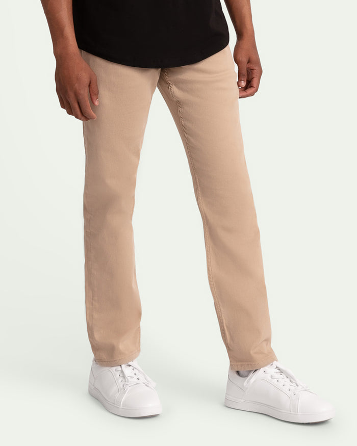 Light khaki slim fit pants with visible seam details, worn with white sneakers and black shirt.