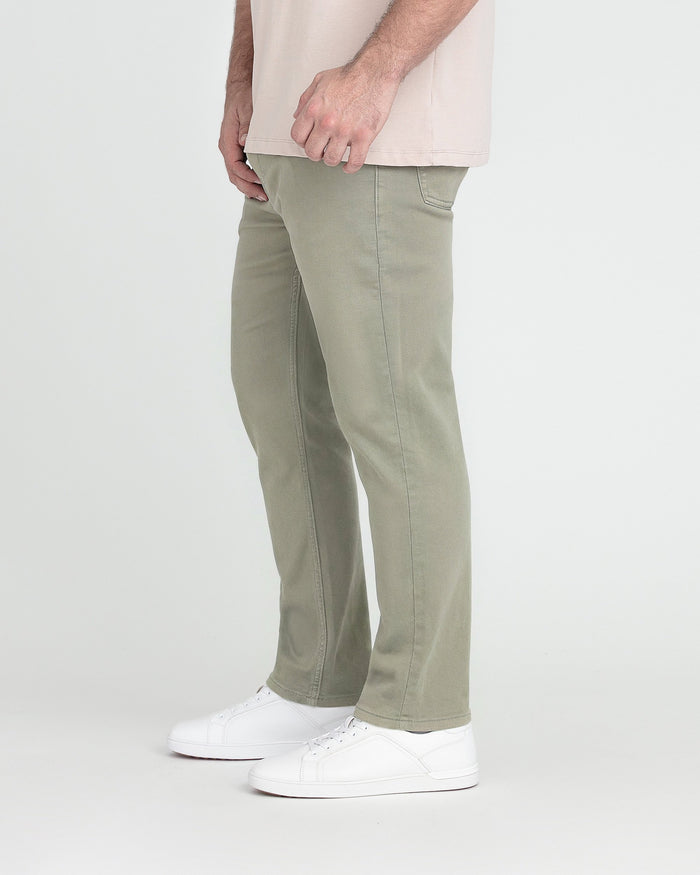 Light green slim fit pants with visible seam detailing, paired with a cream shirt and white sneakers.