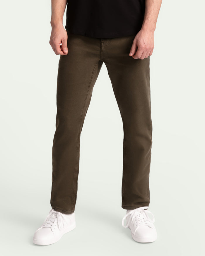 Man wearing black t-shirt and olive green slim fit pants with white sneakers.