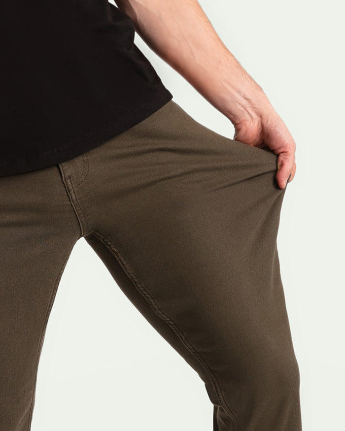 Olive-colored slim fit pants with visible seam details, worn with black shirt.