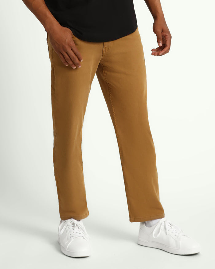 Man wearing black t-shirt and tobacco brown pants with white sneakers.