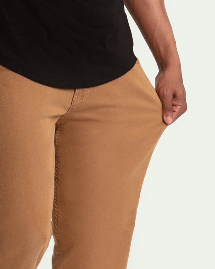 Tan khaki pants with slim fit shown from waist to mid-thigh on model wearing black shirt.