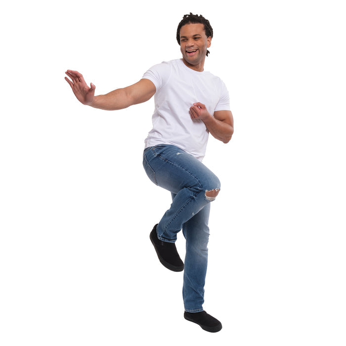 Man wearing white t-shirt and medium blue ripped jeans with distressed thigh openings.