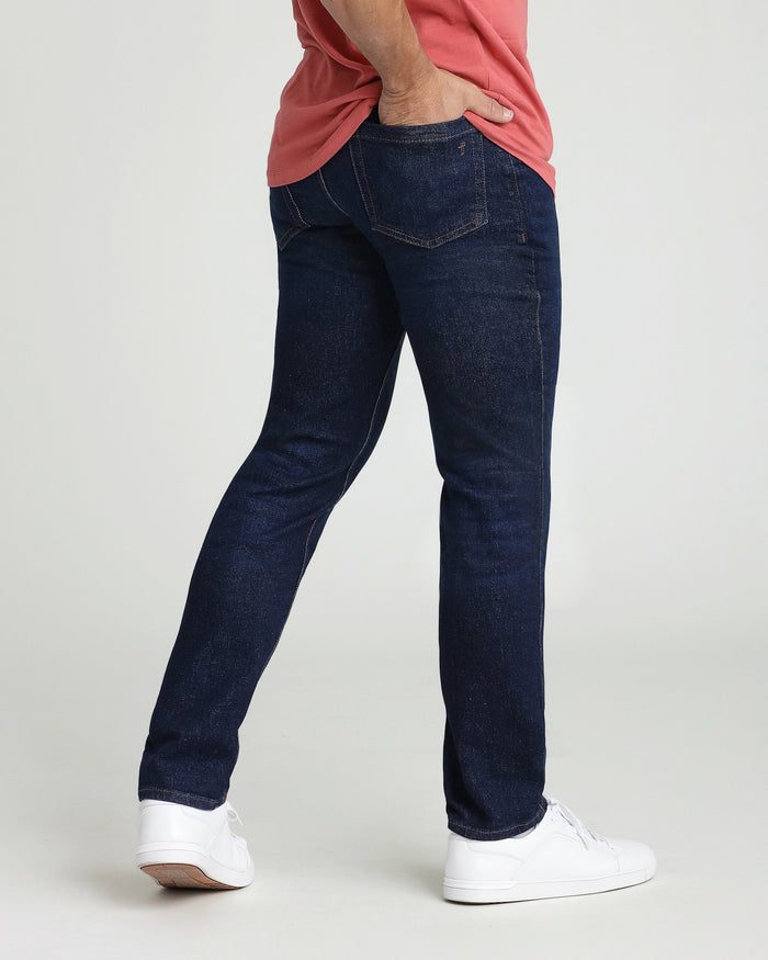 Dark blue denim jeans with straight leg fit and visible stitching detail on back pocket.