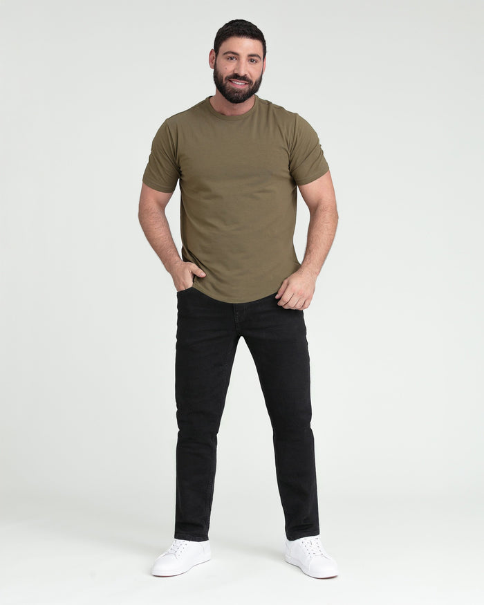 Man wearing olive-green short-sleeve t-shirt with black slim-fit jeans and white sneakers.