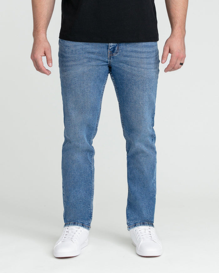 Men's medium blue slim fit jeans with straight leg and button fly closure.
