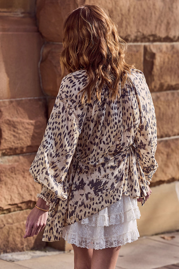Back view of Snow Leopard Asymmetric Blouse showing asymmetrical hem, shirred cuffs, and side tie detail