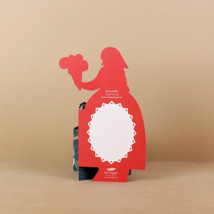 Reverse of the Storyteller die-cut concertina card showing a red silhouette of a woman holding flowers with a blank white message panel framed by a star-burst border, titled Storyteller by Sarah Young, printed by Art Angels